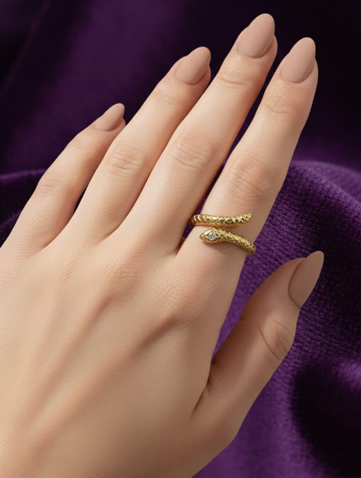 anillo de serpiente dorado envolvente con baño de oro 18k sobre tela morada. Anillo de moda en acero inoxidable resistente al agua, joyería femenina elegante.